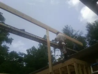 Carpenter setting a ridge beam over a new addition frame — Ice Dam Removal by Roofing Brothers in Dalmatia