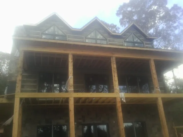 Dormers and porch framing on a large log home under construction — Roof Coating work by our crew in Dalmatia