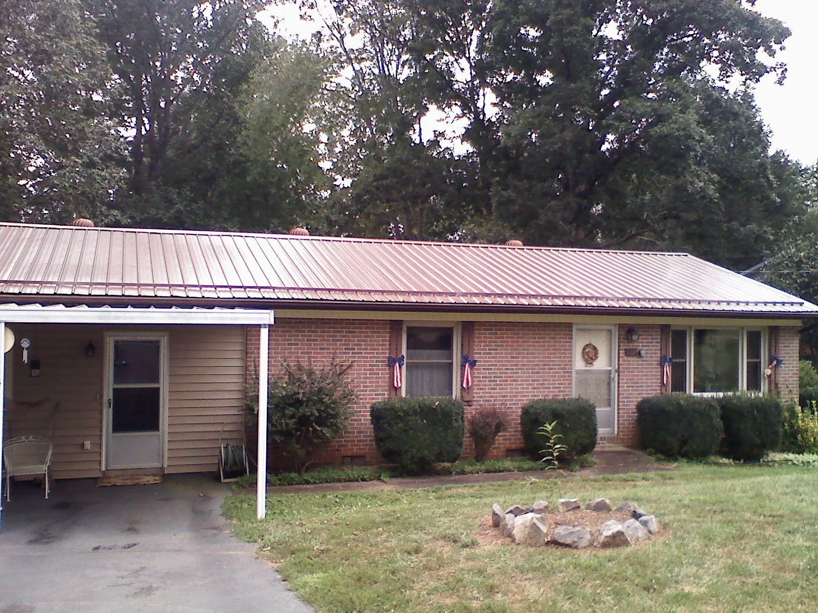 Bronze metal roof and carport on a brick ranch home — Roof Repair work by our crew in Dalmatia