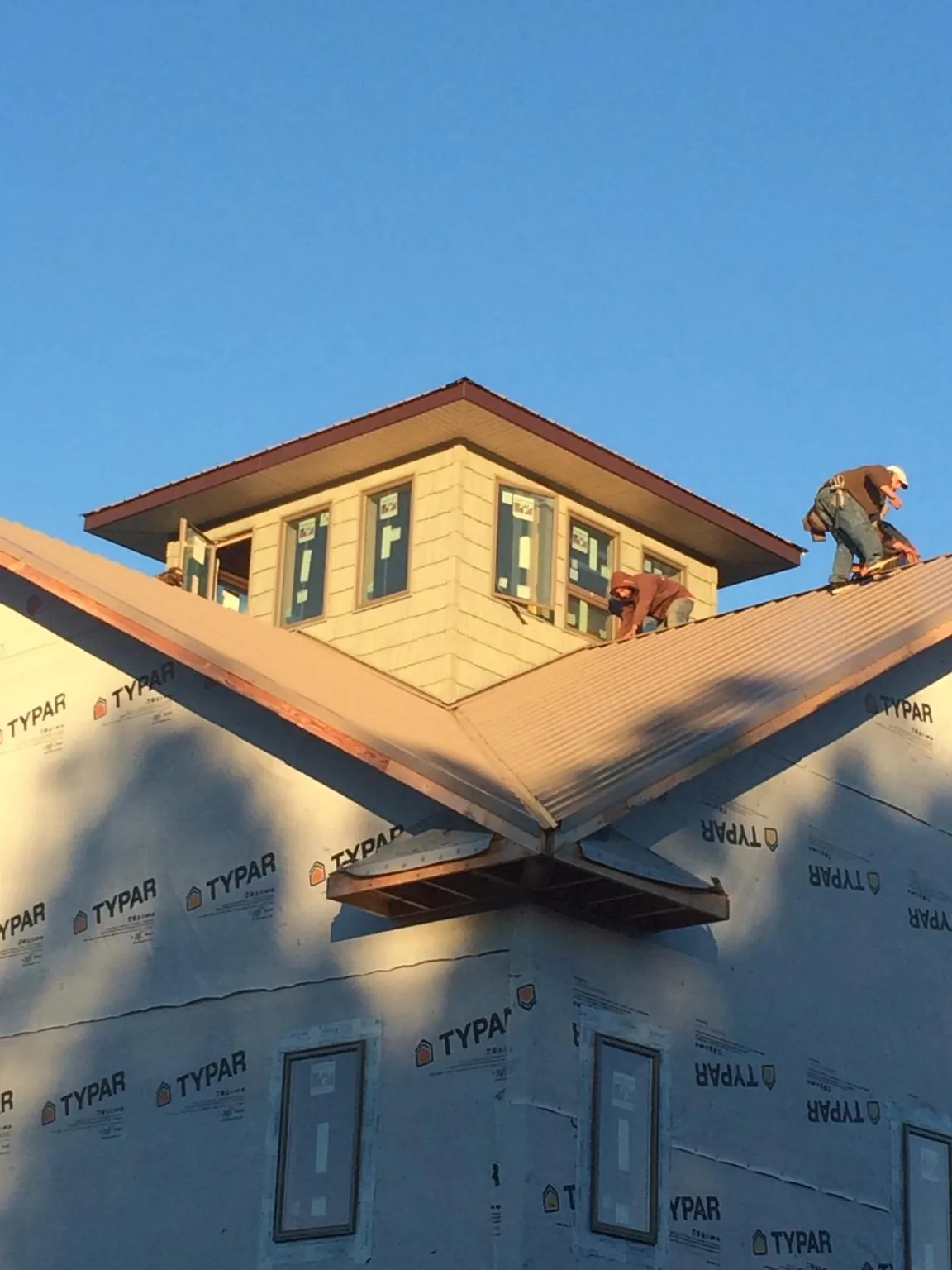 Roofers working around a rooftop cupola on a new metal roof at sunset — Roof Waterproofing in Dalmatia by Roofing Brothers